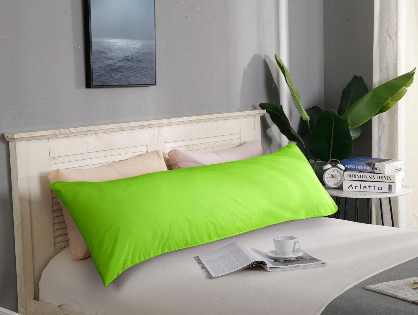 Green body pillowcase on bed, smooth solid fabric with edge