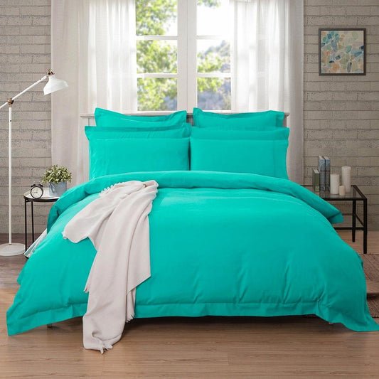 Teal duvet cover set with matching pillow shams, neatly arranged on a bed