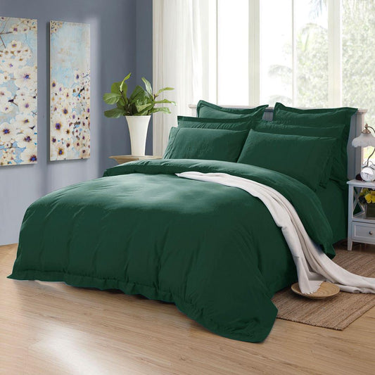 Dark green quilt and duvet cover set on bed with two matching pillow shams