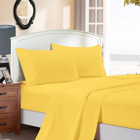 Yellow bed sheet set with matching pillowcases, neatly laid on a bed