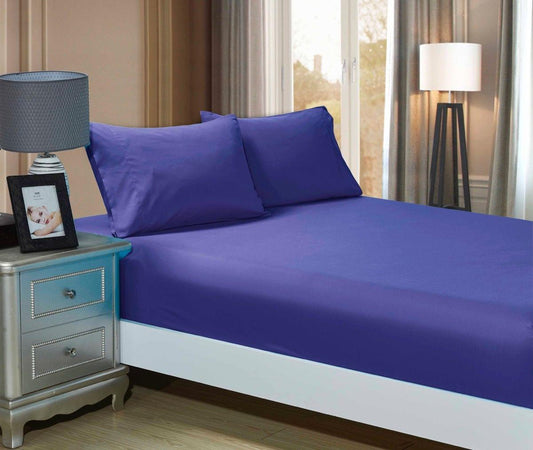 Royal blue fitted sheet with two matching pillowcases on a bed