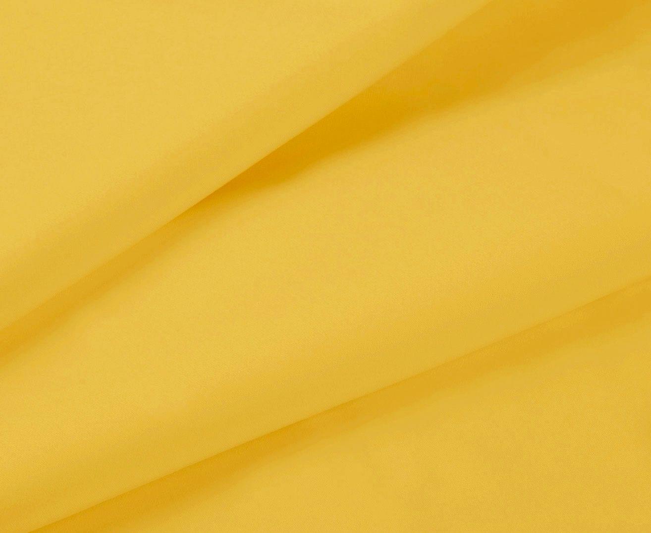 Yellow fabric close-up with draped folds from a fitted sheet