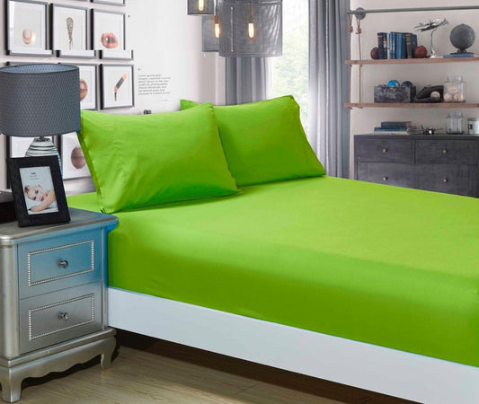 Green fitted sheet and pillowcase set on a single bed, smooth surface