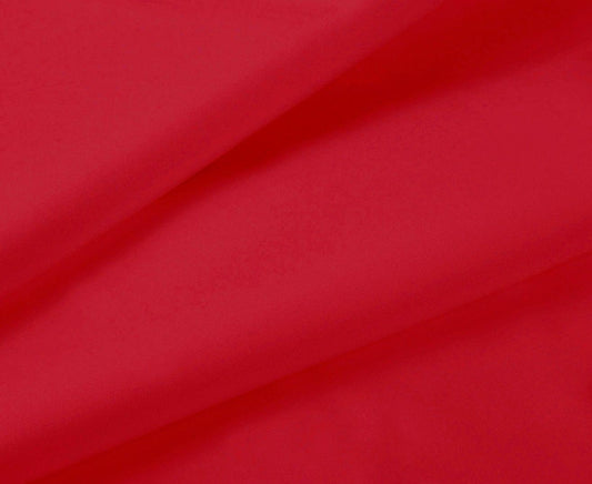 Red fitted sheet fabric closeup with smooth folds