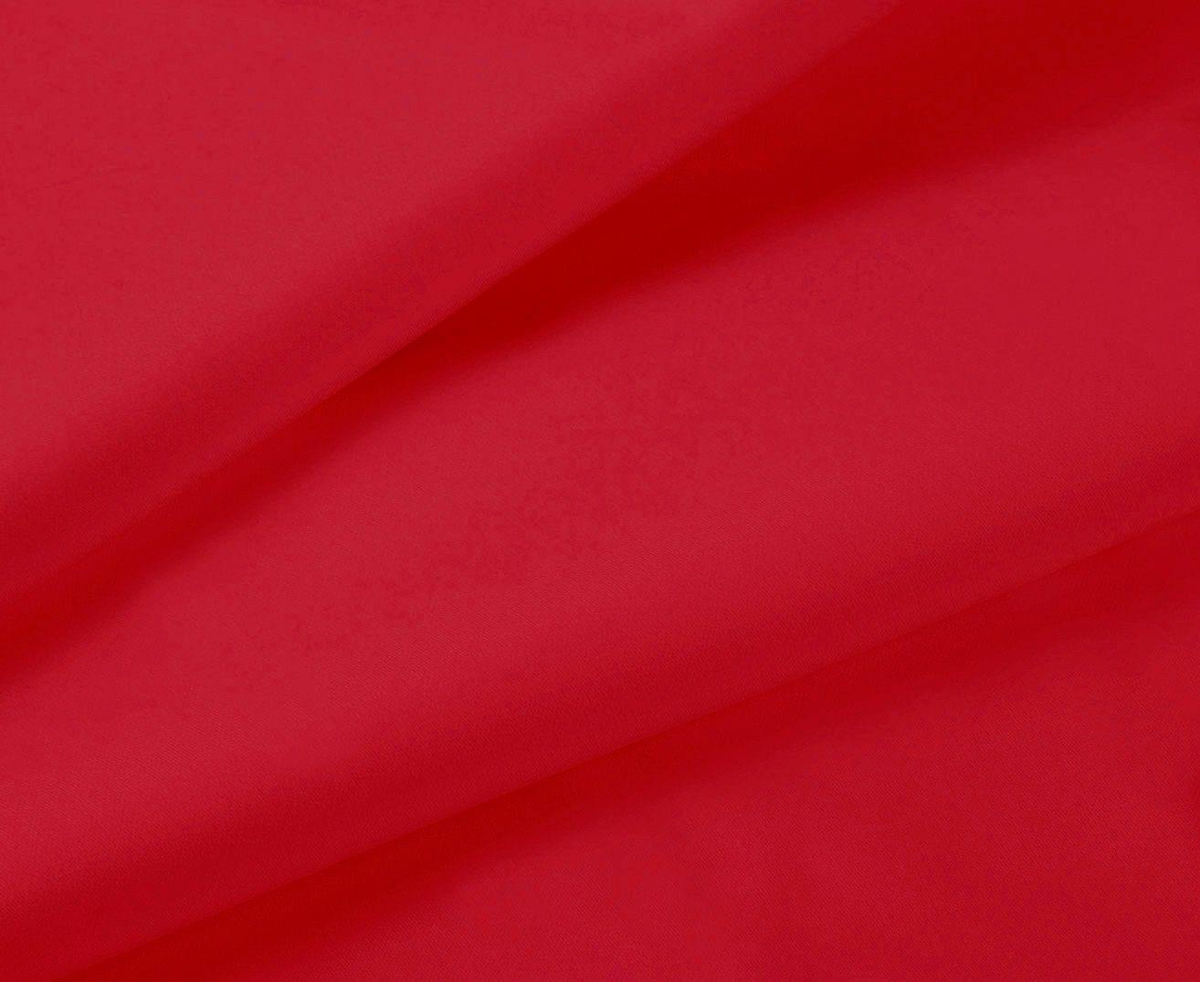 Red bed sheet fabric close-up with smooth finish and visible folds