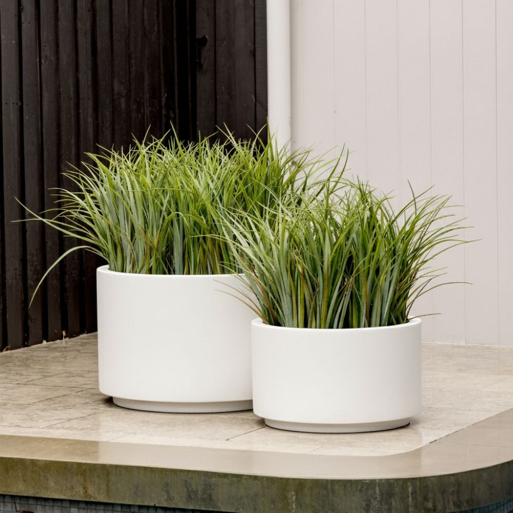 Round outdoor plant pot set with two white planters and green grass