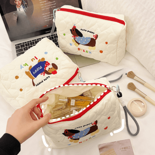 White quilted cosmetic bag with red zipper; puppy-themed print on front