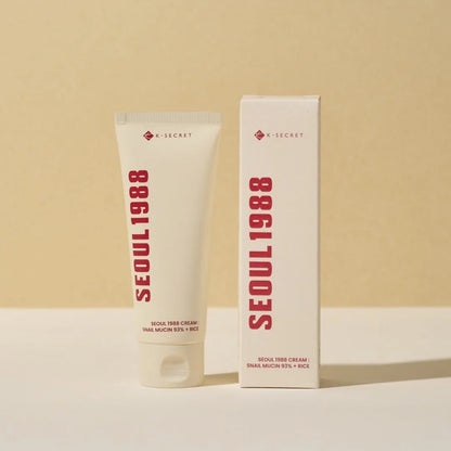 Two K-SECRET cream tubes standing side by side, cream-colored facial moisturizer