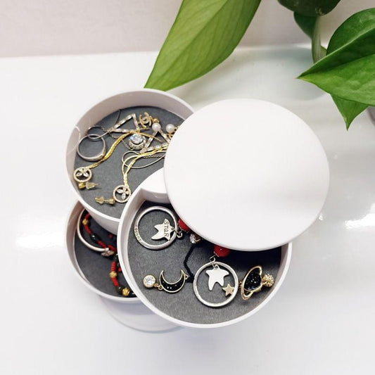 White rotating jewelry storage box with open lid and stacked round compartments