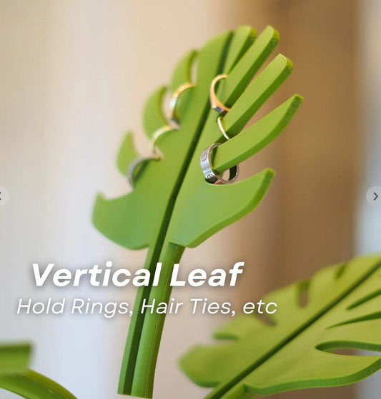 Green monstera leaf mirror-mount with curved rings for hair ties and small items