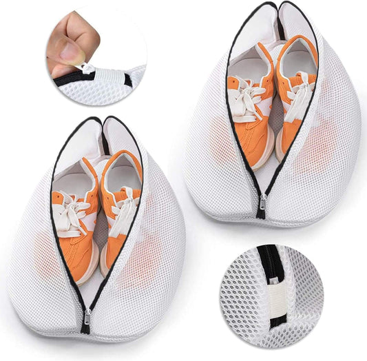 White mesh shoe wash bag with black zipper, holding a pair of sneakers