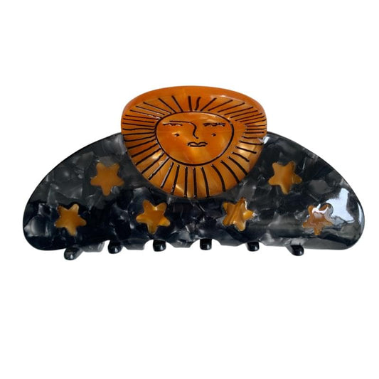 Medium hair claw clip with black star pattern and orange lion sun face center