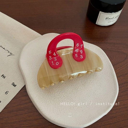 Beige acrylic hair claw clip with red numbered handle for hold