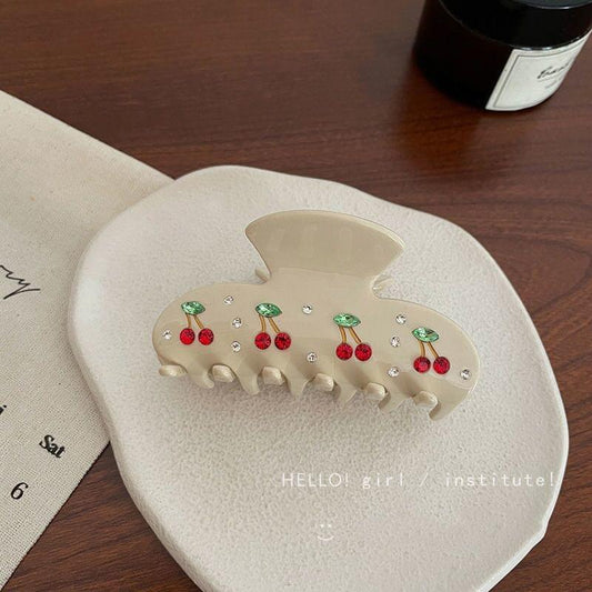 Cream acrylic hair claw clip with rhinestone cherry pattern and polished claw teeth
