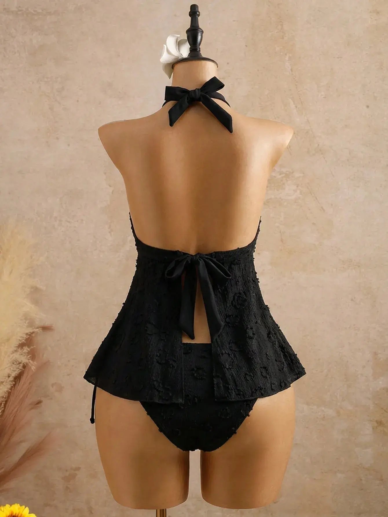 Black textured halter peplum bikini set with bow-tie back and high-cut bottoms