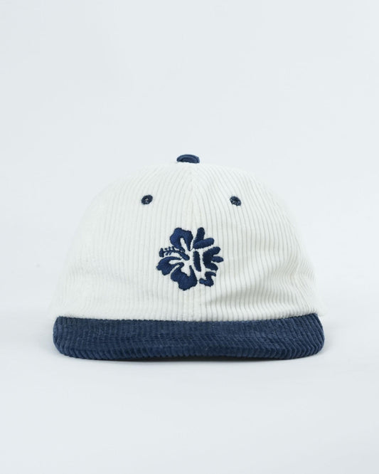 Ribbed knit cap with navy brim and blue flower patch on white crown