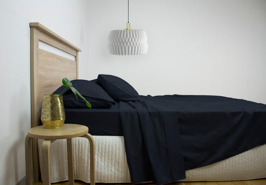 Queen cotton-rich sheet set in dark navy, folded on bed