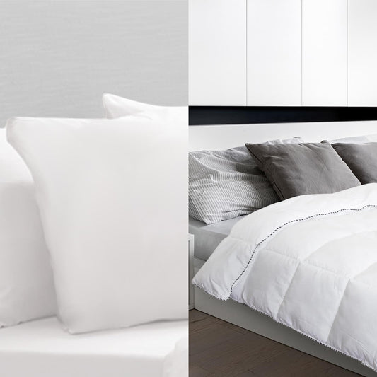 White bedding set with quilt and pillow on a bed, shown from a side angle