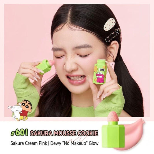 Skincare liquid blush with green case and pink applicator sponge, held near cheeks