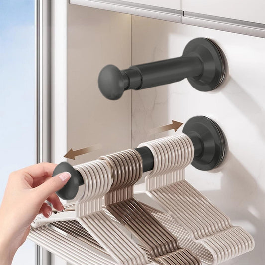 Retractable clothes hanger rack with black suction-cup mounts and beige ribbed hangers
