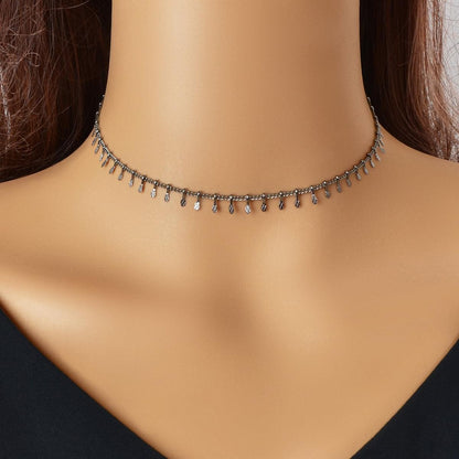 Dark-tone thin choker necklace with small dangling charms across the neckline.