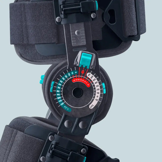 Knee ROM brace dial control with colored range markings and teal/black hinged mechanism.