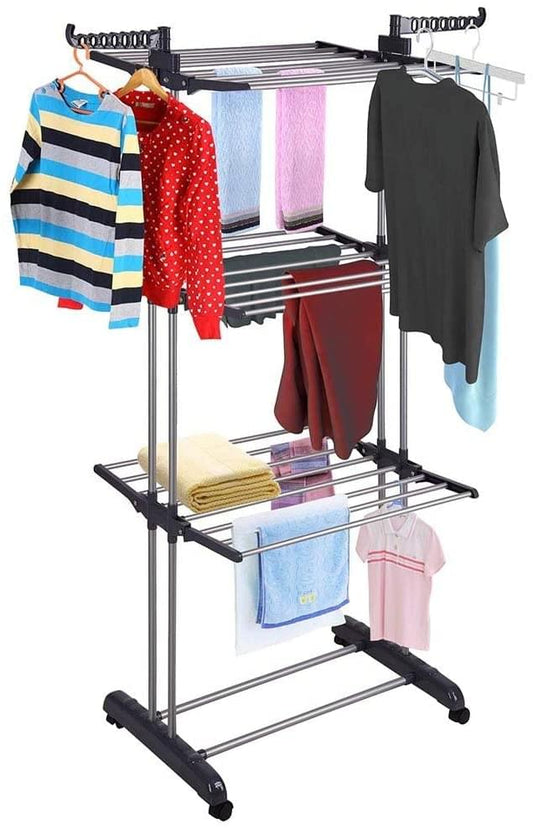 Clothes drying rack with hanger rail; towels and shirts hanging on three wire shelves