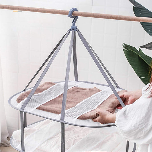 3-tier folding clothes drying rack with mesh shelves holding a sweater flat