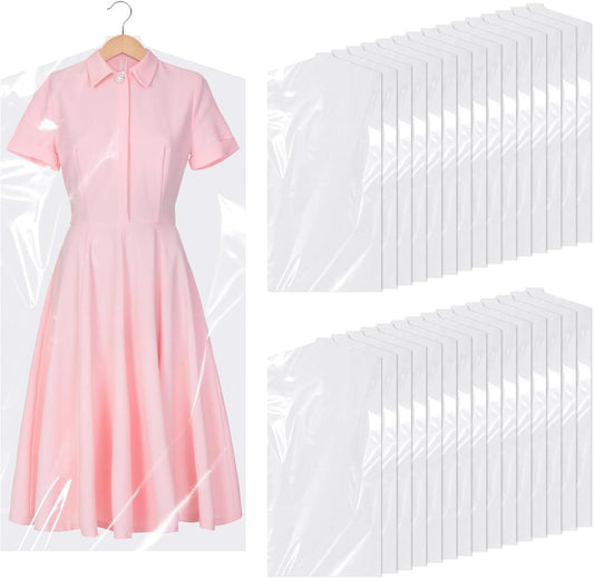 Clear plastic garment bag over a pink dress, with stacked bags beside it.