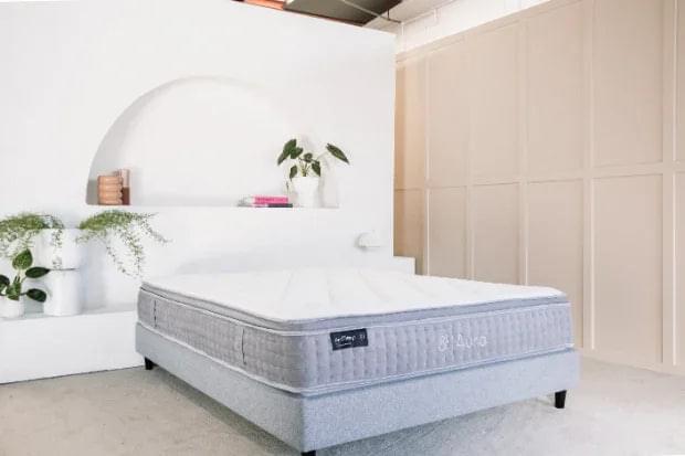 Light gray upholstered mattress with black edge label and dark base