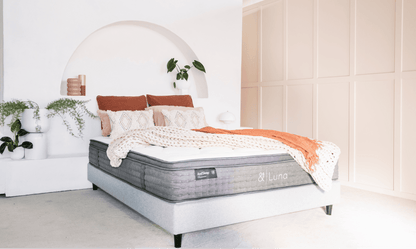 Gray upholstered mattress with quilted top, shown on a bed frame with throw