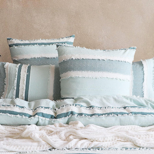 Light blue quilt cover set with white ruffle trim and multiple striped pillowcases