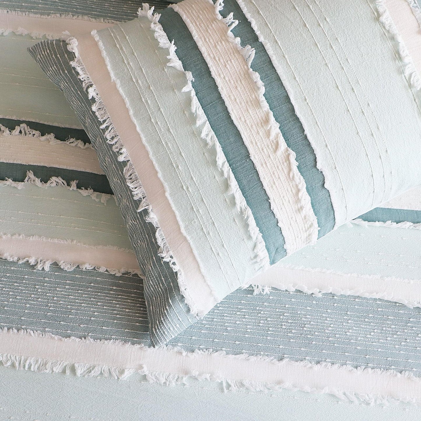 Striped quilt cover detail with light blue bands and white ruffled edging