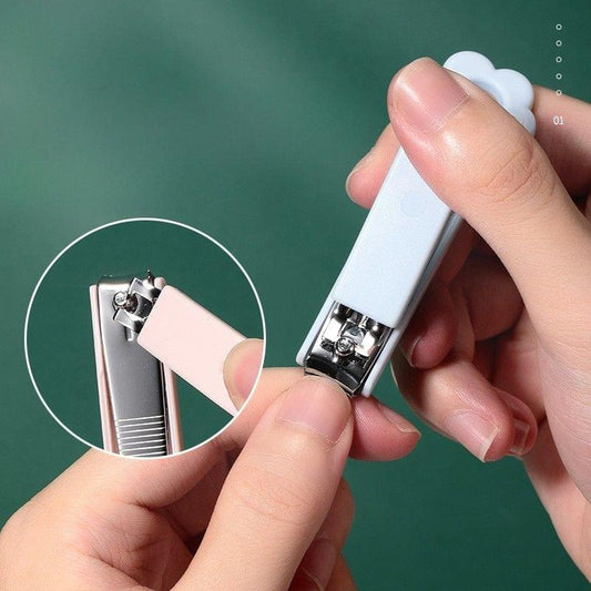 White nail clipper in use held by hand; silver cutting blades