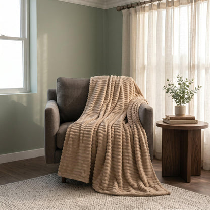 Light coffee ribbed flannel throw blanket covering sofa with thick layered folds