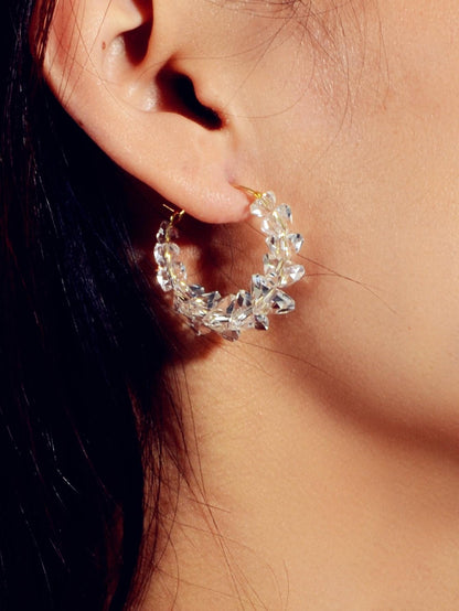 Clear acrylic bead hoop dangle earring on ear with gold-tone hook