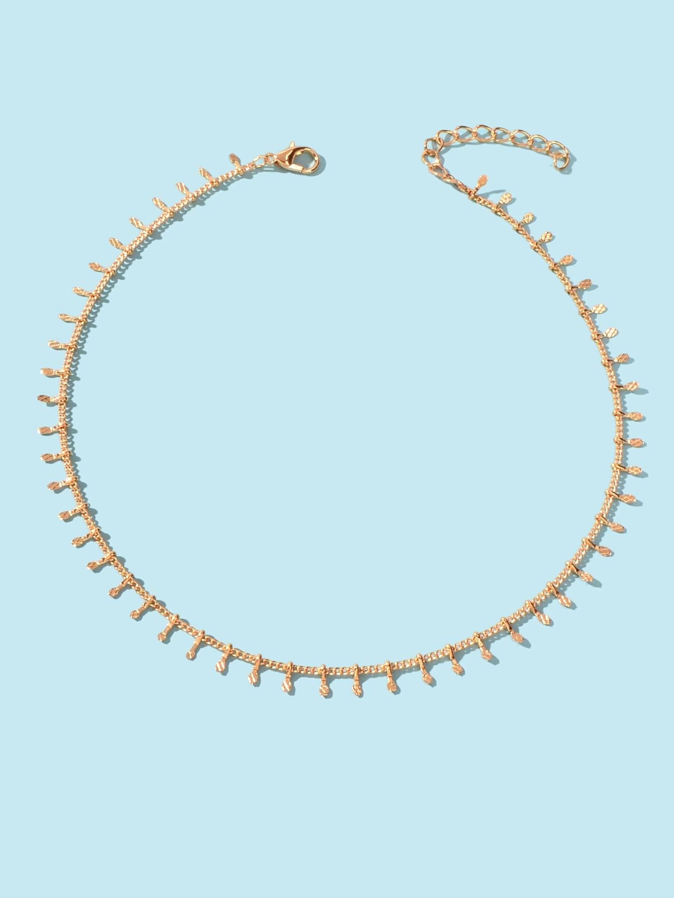 Gold-tone short chain choker with evenly spaced mini dangling charms and clasp.