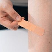 Adhesive bandage strip applied to forearm