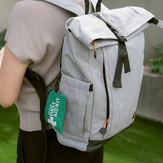 Mini first aid kit pouch clipped to a backpack, green zip case with cross logo