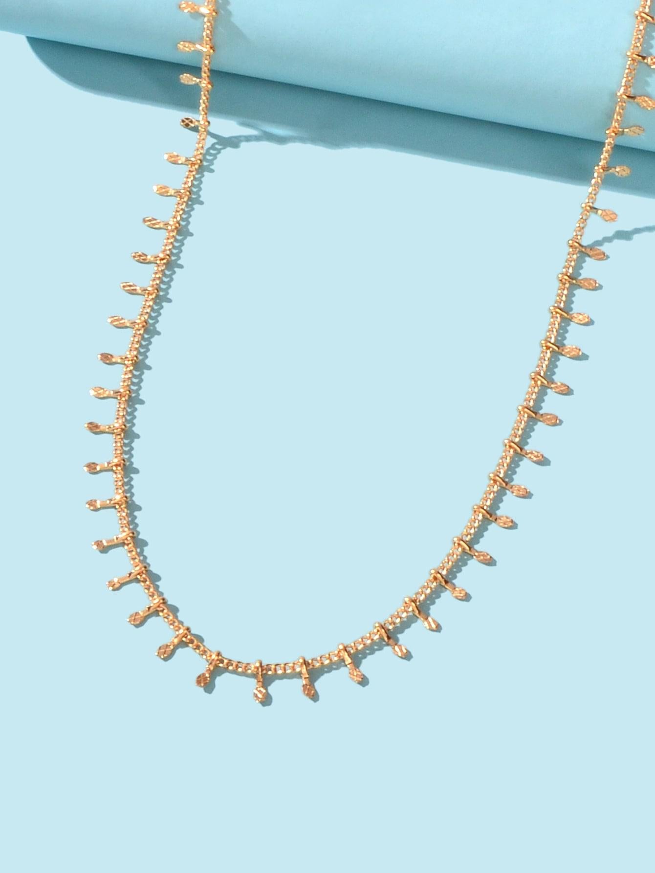 Gold-tone short chain choker necklace with mini dangling charms and oval clasp loops.
