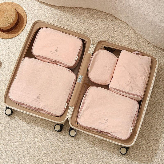 Pink packing cubes inside luggage case with four folded organizers and zip pockets