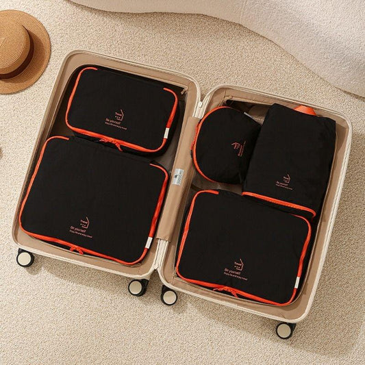 Nylon packing cubes with zippers, dark fabric and orange trim in travel case