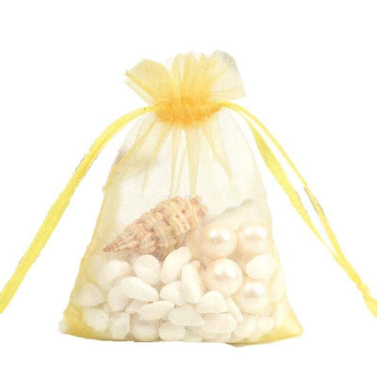 Yellow sheer organza pouch with drawstring, filled with small white candies