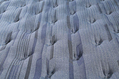 Close-up of blue mattress padding with plush ridges and vertical fabric channels
