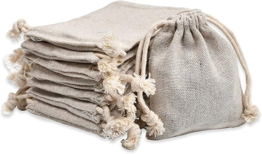 Stack of light beige muslin drawstring pouches with tassel cords