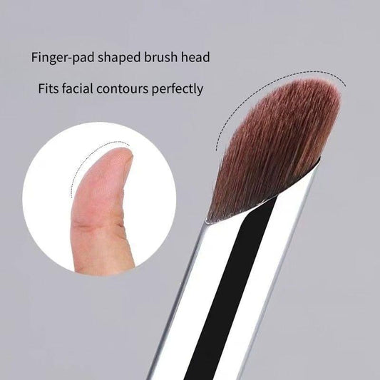 Finger-pad shaped brush head with brown bristles on a silver-and-black concealer brush