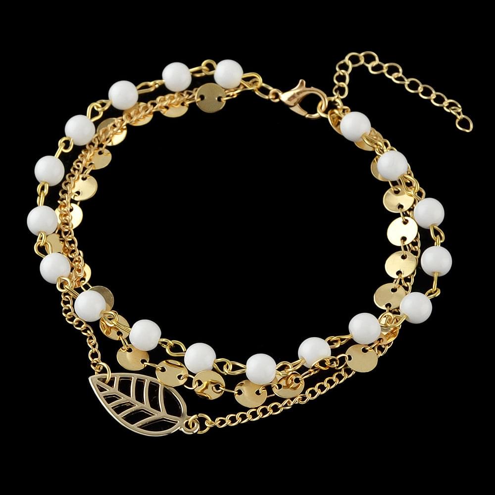 Gold-tone layered anklet featuring white beads, coin discs, and leaf charm with clasp