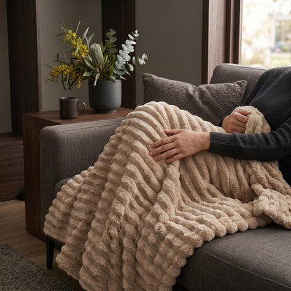 Light coffee ribbed flannel throw blanket on sofa, one section folded back
