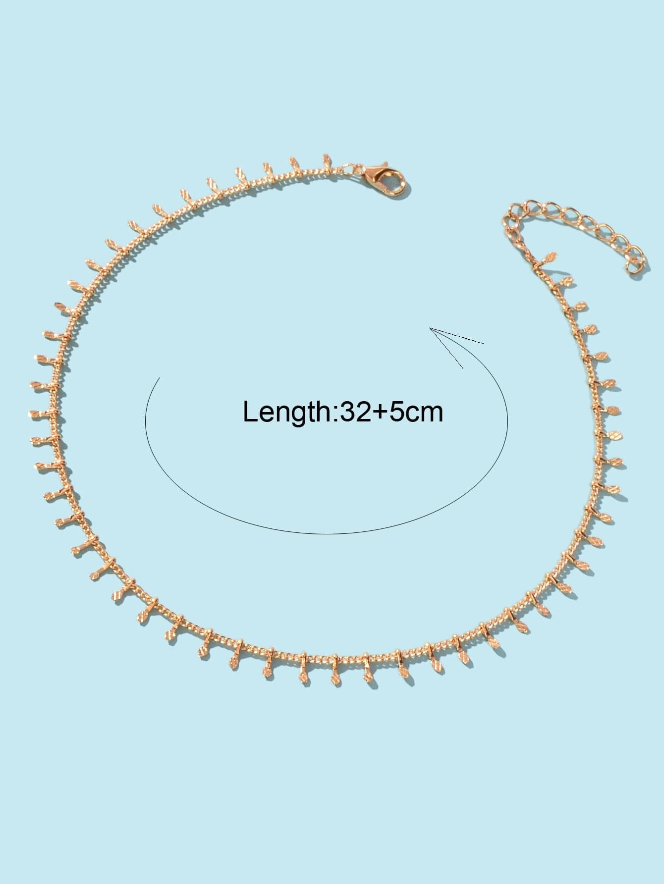 Gold-tone thin chain choker with mini dangling charms and small side clasp at top.