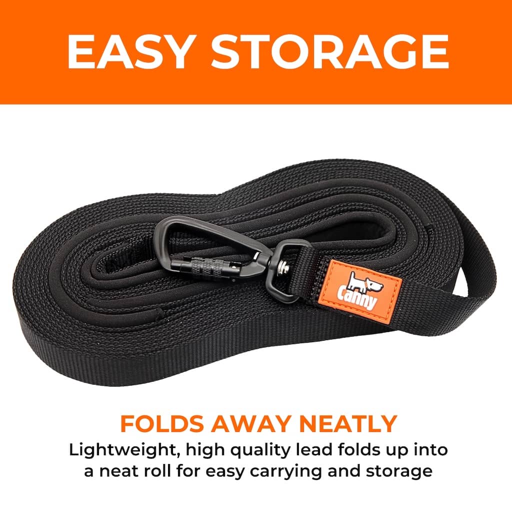 Black dog recall lead folded neatly with metal clip and orange brand tag on handle